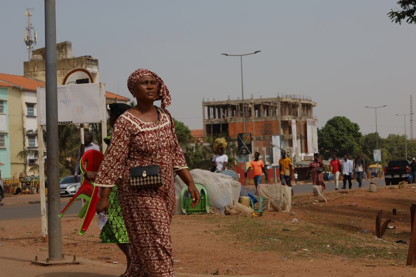 People walk on the street in Bissau, Guinea-Bissau, Wednesday, Nov. 26, 2025. (AP Photo/Darcicio Barbosa)