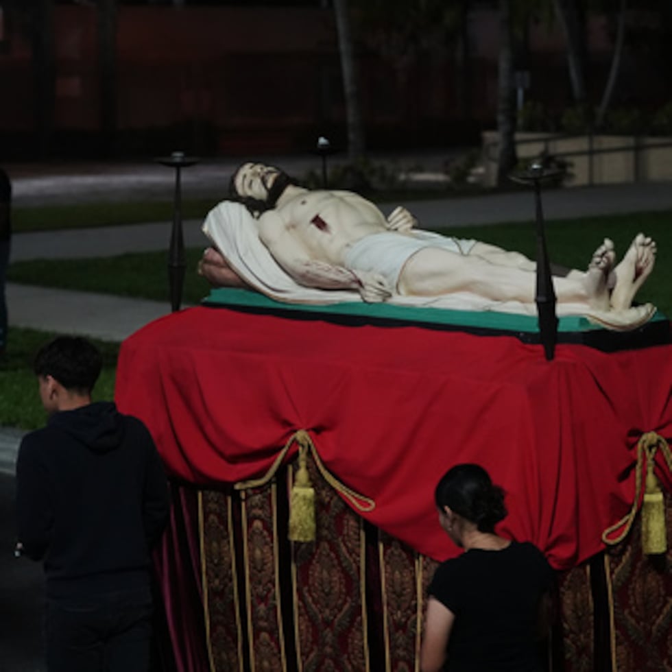 Miembros del grupo juvenil de la Iglesia Católica Corpus Christi empujan una carroza con Jesús durante un ensayo para su procesión del Viernes Santo.