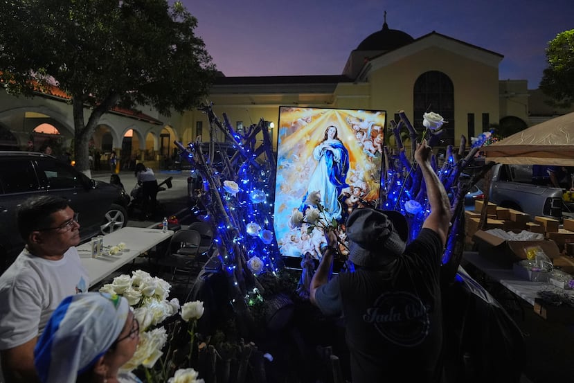 Un grupo decora su altar a la Virgen María, frente a la Iglesia Católica San Juan Bosco, durante las celebraciones de la Inmaculada Concepción, el domingo 7 de diciembre de 2025, en Miami. (Foto AP/Rebecca Blackwell)