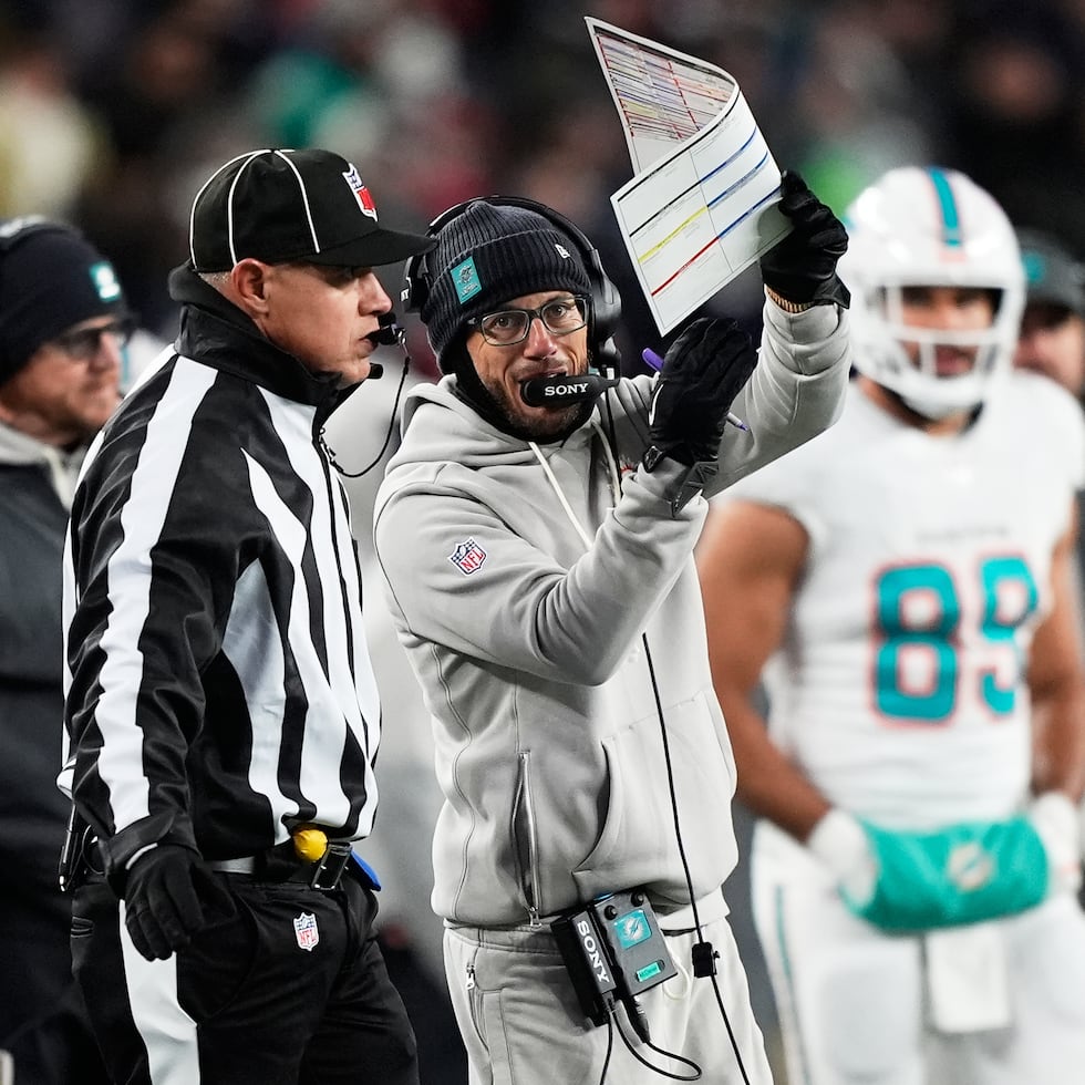 El ahora exentrenador de los Dolphins de Miami, Mike McDaniel, habla con los oficiales en el encuentro ante los Patriots.