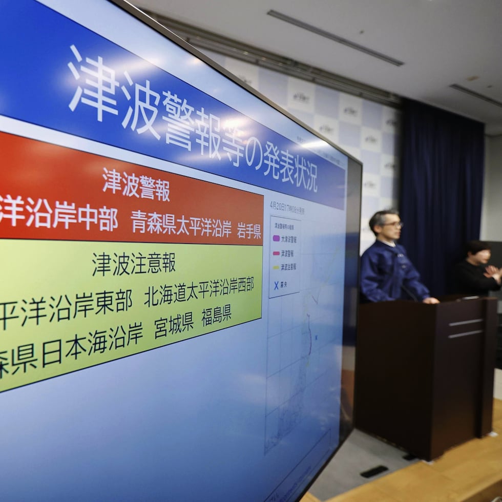 Un funcionario de la Agencia Meteorológica de Japón habla cerca de un monitor que muestra una alerta de tsunami durante una conferencia de prensa en la agencia en Tokio.