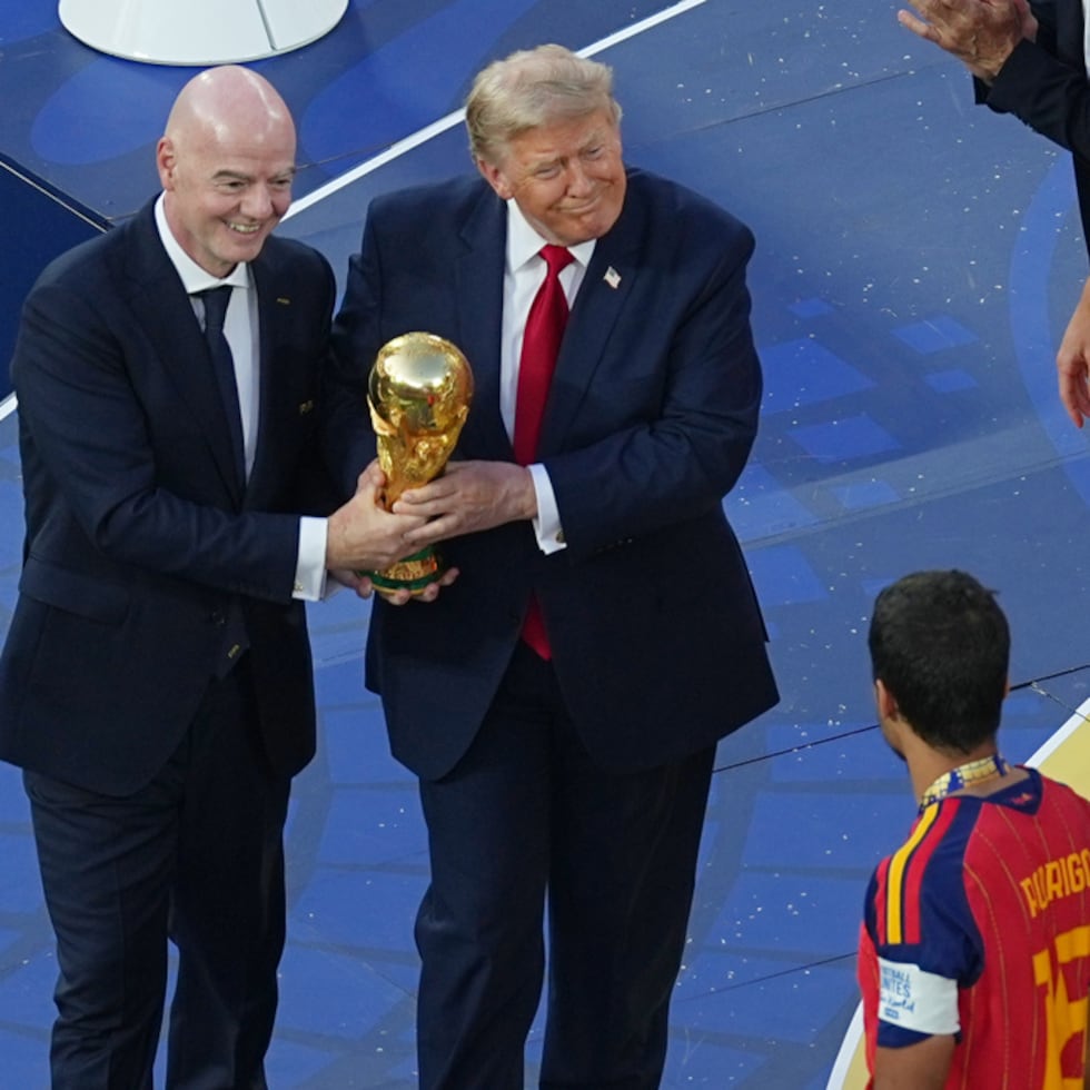 El presidente de la FIFA, Gianni Infantino, y el presidente Donald J. Trump entregan el trofeo al español Rodri (16) después del partido final de fútbol de la Copa del Mundo entre España y Argentina.