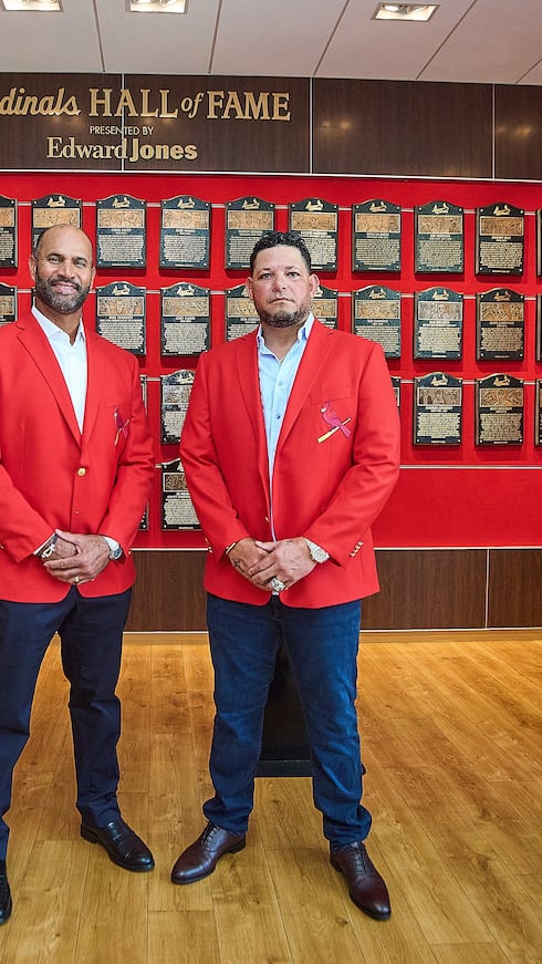 Yadier Molina y Albert Pujols posan con sus chaquetas rojas tras ser exaltados al Salón de la Fama de los Cardinals de San Luis.