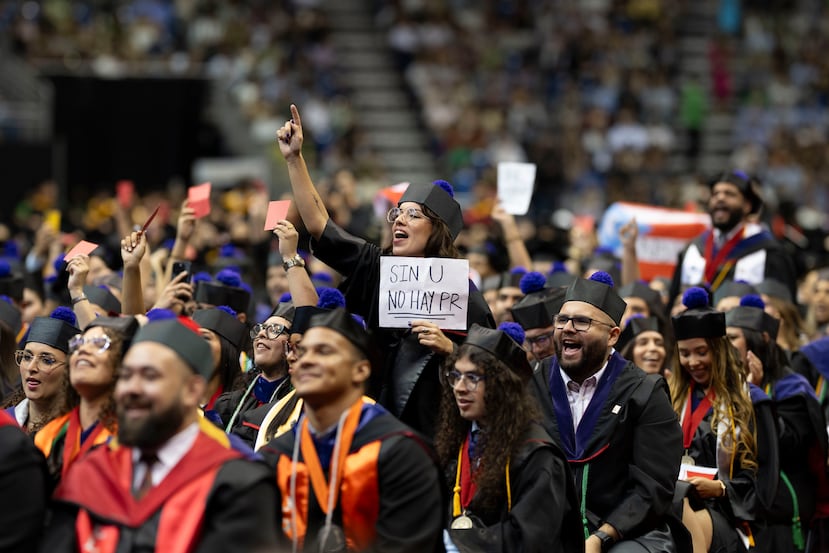 Una graduanda sostiene un papel que lee “Sin U no hay PR”.