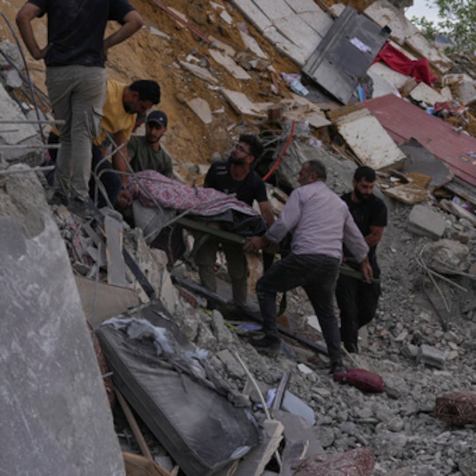 Unas personas transportan el cadáver de una persona que murió en una vivienda alcanzada por un ataque aéreo israelí en la localidad de Arab Salim, en el sur del Líbano, el domingo.