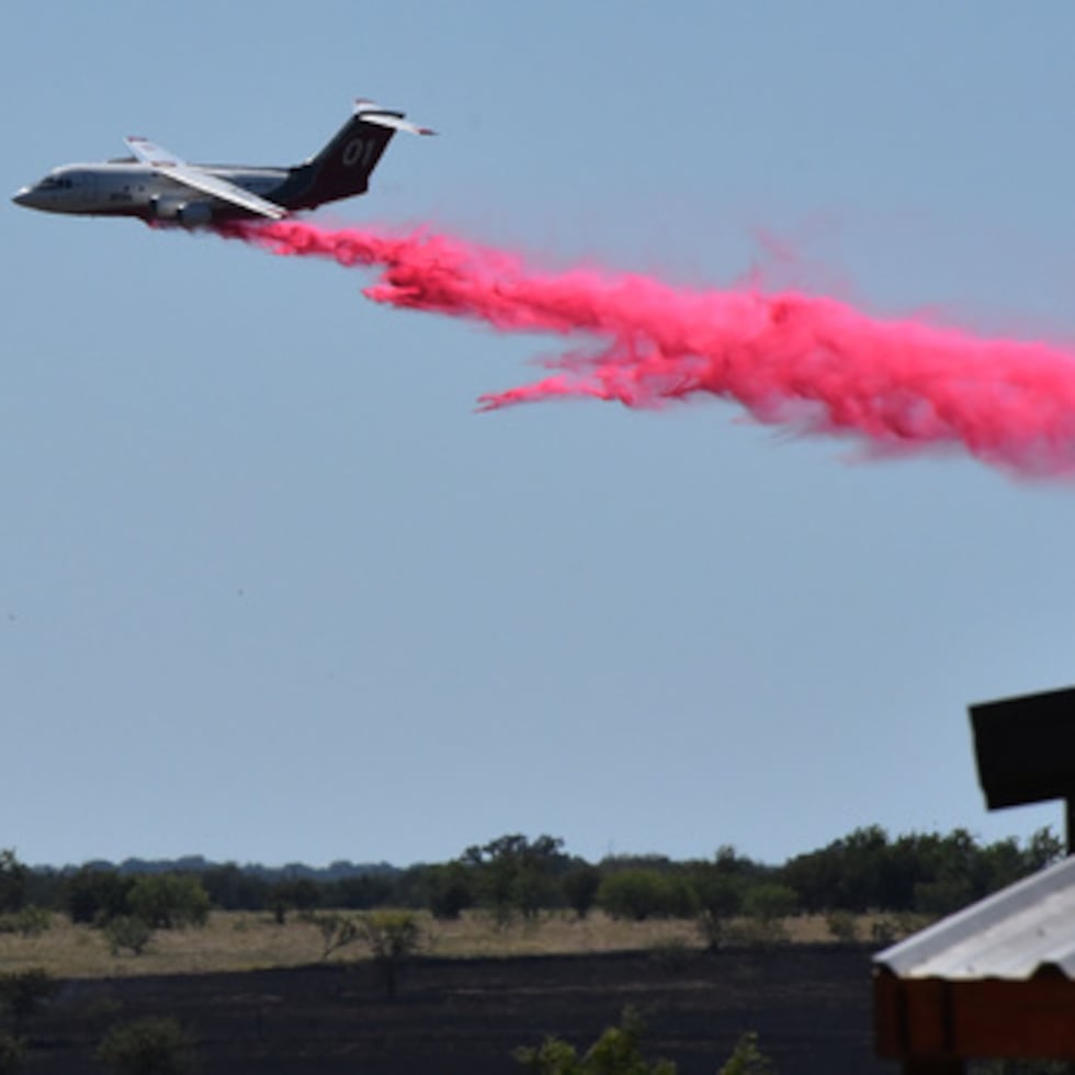 Un avión cisterna vierte retardante de incendios sobre un campo al suroeste de Salado, Texas, el miércoles 12 de agosto de 2026, tras el accidente de un helicóptero militar que provocó un incendio de matorral.