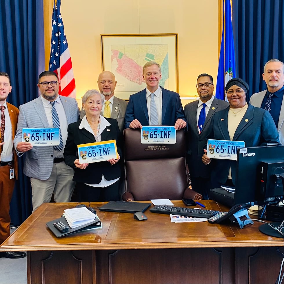 El representante Geraldo Reyes (a la derecha, con espejuelos) fue el copatrocinador de la medida. En la foto aparecen varios legisladores, incluyendo al presidente de la Cámara, Matthew Ritter (centro).