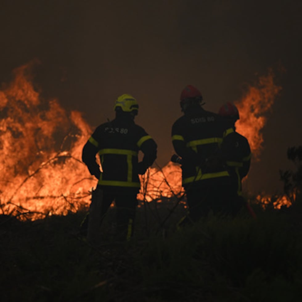 Los bomberos lanzan agua sobre un incendio forestal cerca de Lacanau, en el suroeste de Francia.