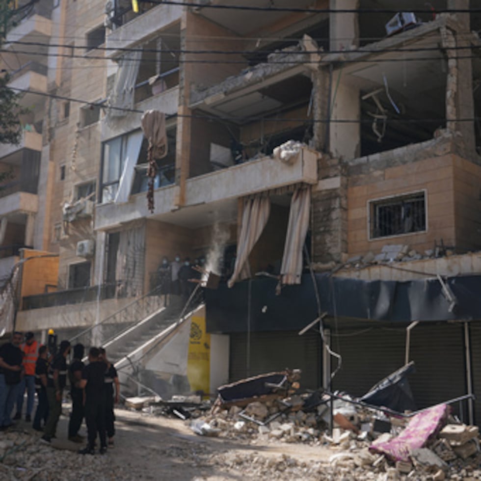 Agentes de seguridad libaneses se reúnen en el lugar donde un ataque aéreo israelí alcanzó un edificio en Dahiyeh, suburbio del sur de Beirut, Líbano