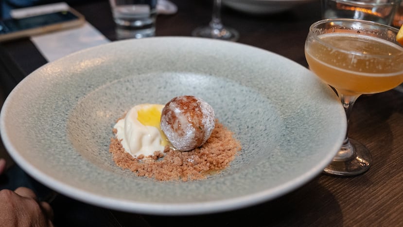 Mini dona de naranja y ricota, crema de ricota y ron con cuajada de limón, y migas de coco y caramelo de Prole Cocina & Barra.