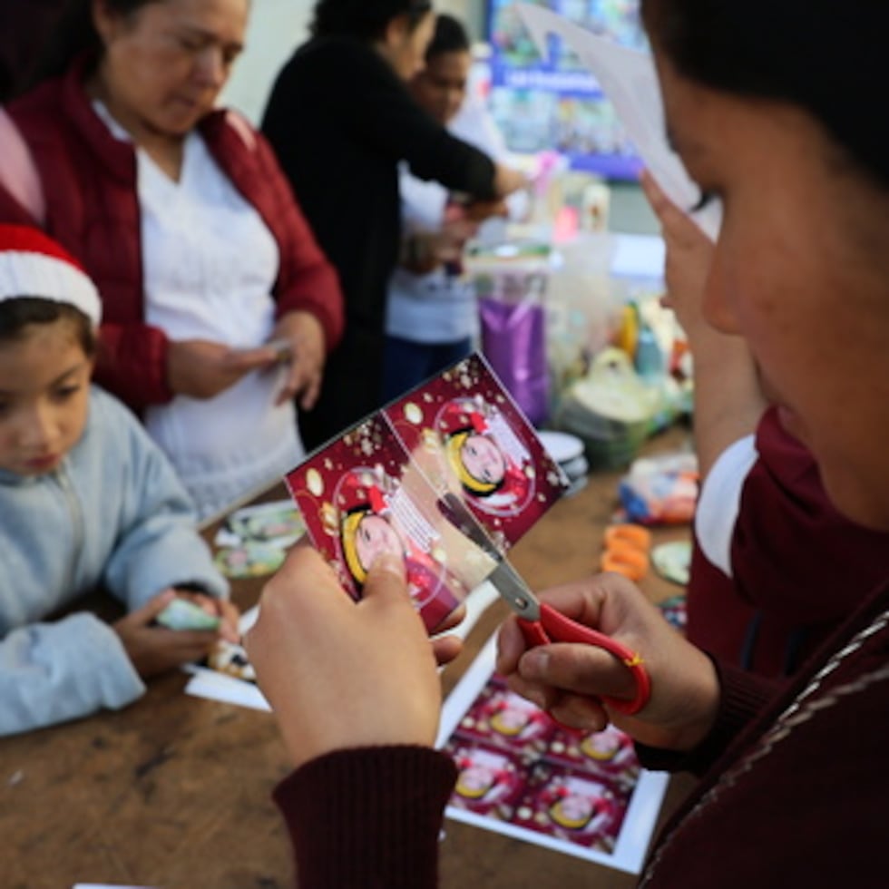 La hermana María Elena recorta una fotografía de una niña desaparecida para pegarla en un adorno navideño para colgar en el Árbol de la Esperanza, durante un evento organizado por la diócesis de Ecatepec en la Iglesia del Sagrado Corazón de San Cristóbal en Ecatepec, Estado de México, el lunes 17 de noviembre de 2025. (AP Photo/Ginnette Riquelme)