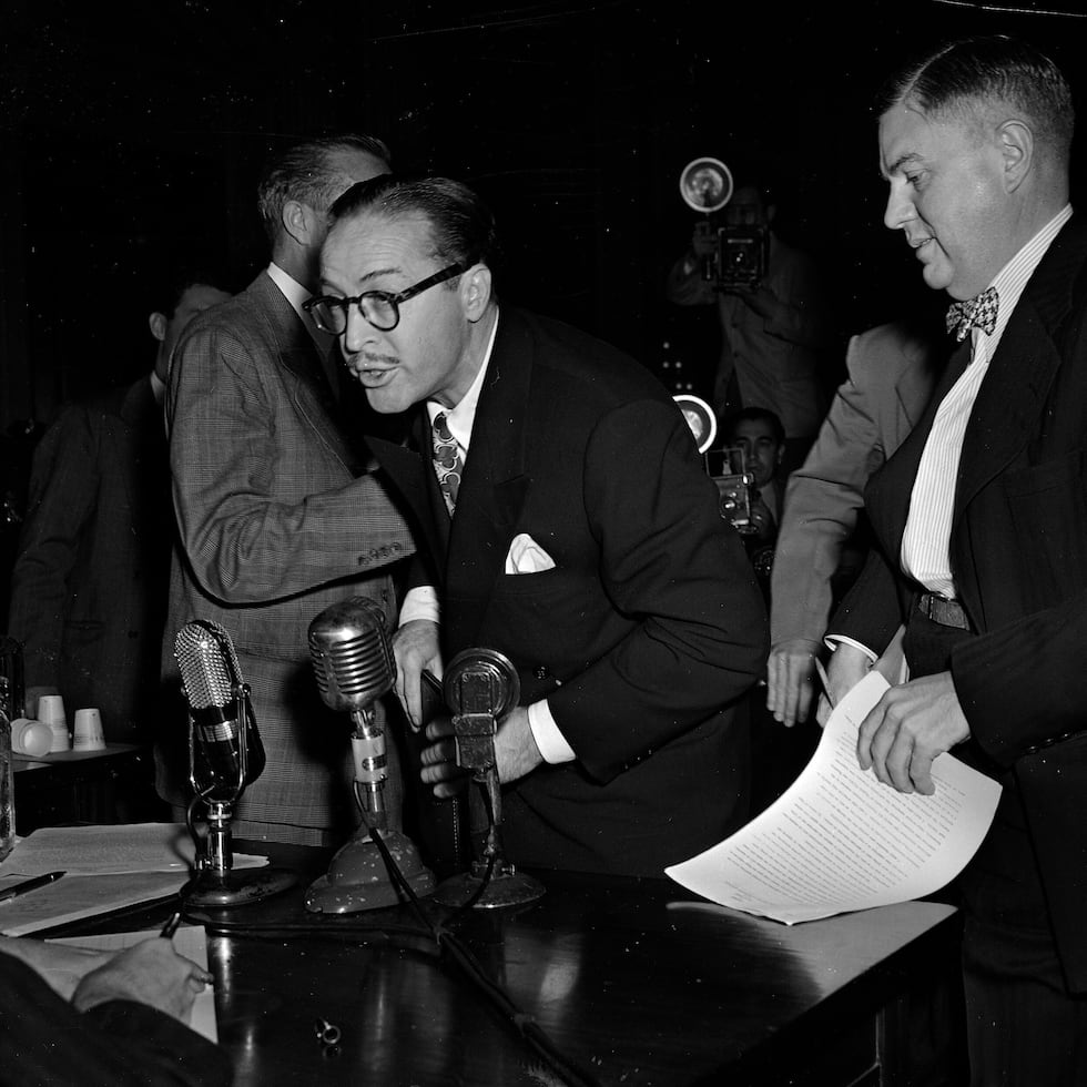 Dalton Trumbo, izquierda, guionista de Hollywood, grita desde el banquillo de los testigos mientras trata de hacer una declaración ante el Comité de Actividades Antiestadounidenses de la Cámara de Representantes, el 28 de octubre de 1947, en Washington. A su derecha está su abogado Robert Kenny. A Trumbo se le excusó de presentar más testimonios cuando se rehusó a declarar si era o había sido comunista.