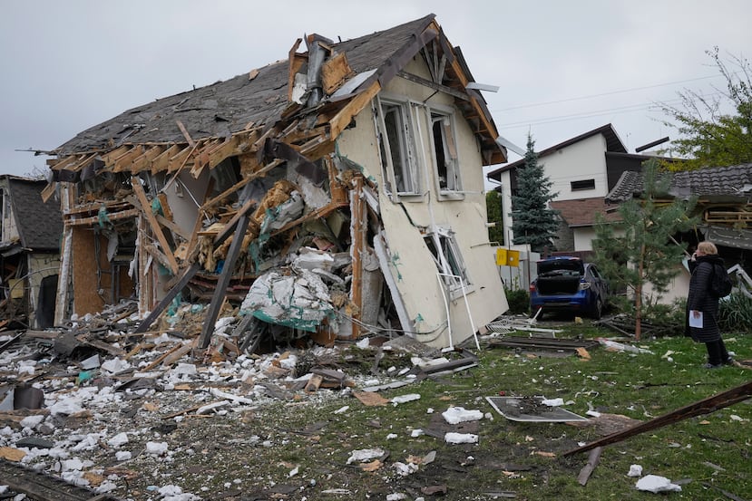 A woman looks at residential house destroyed in a Russian missile strike in Kyiv, Thursday, Oct. 22, 2026. (AP Photo/Efrem Lukatsky)