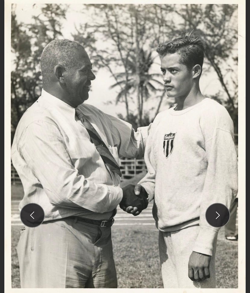 Rolando Cruz (derecha), recibiendo un saludo del entonces entrenador del Equipo Nacional de atletismo, Carlos Cartagena, en 1955.