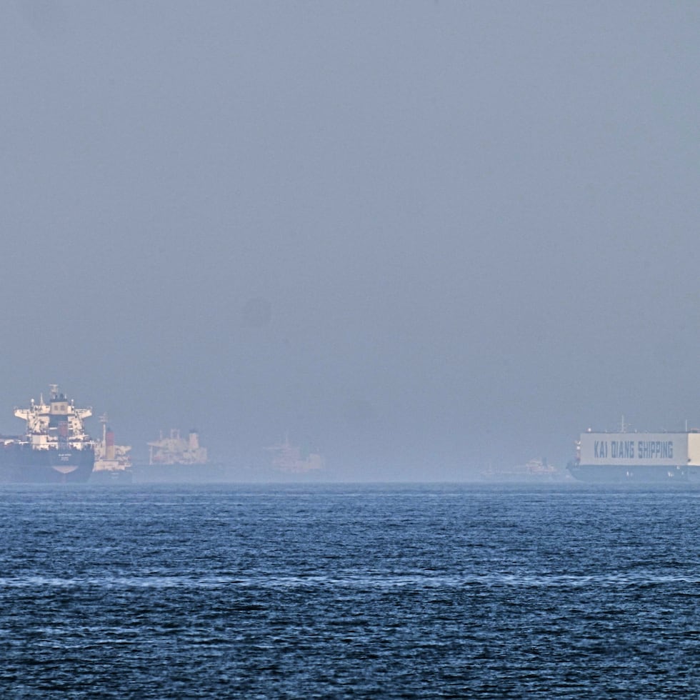 Un petrolero (izquierda) y un barco con autos, fondeados en el golfo de Omán, cerca del estrecho de Ormuz.