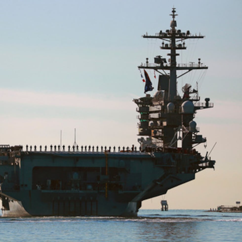 Marineros e infantes de marina se alinean en la cubierta del portaaviones USS Abraham Lincoln (CVN-72) mientras zarpa de San Diego.