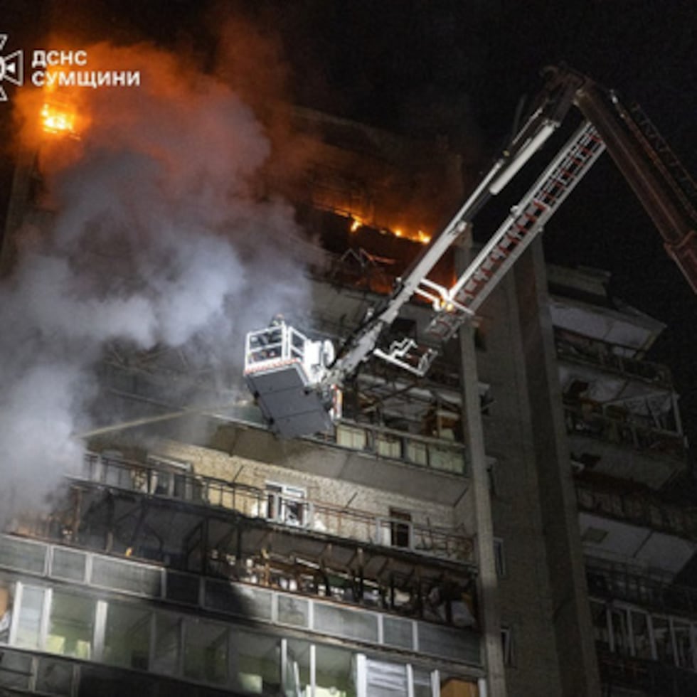 En esta foto proporcionada por los Servicios de Emergencia de Ucrania, los trabajadores de rescate apagan el incendio de un edificio residencial dañado tras un ataque ruso en Sumy, Ucrania.