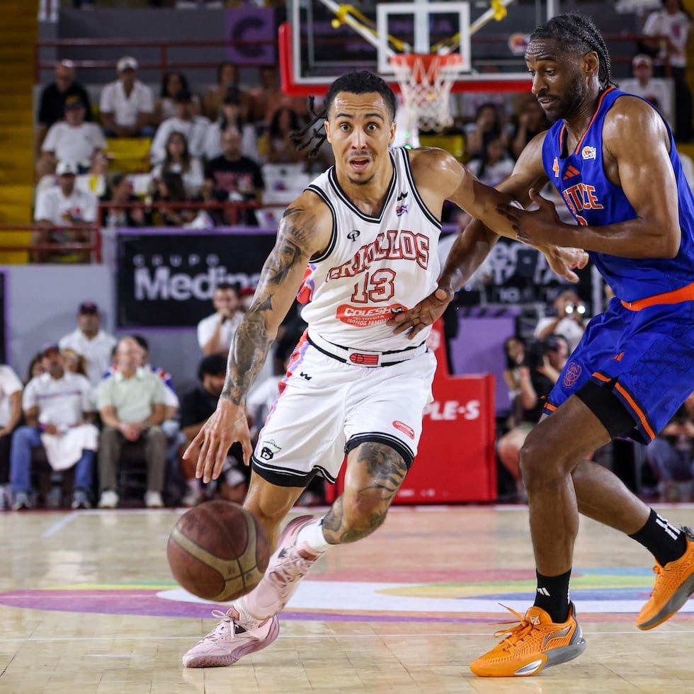 Travis Trice busca atacar el canasto ante la defensa de Ian Clark en el primer juego de la semifinal de la Conferencia A entre los Cangrejeros y los Criollos.
