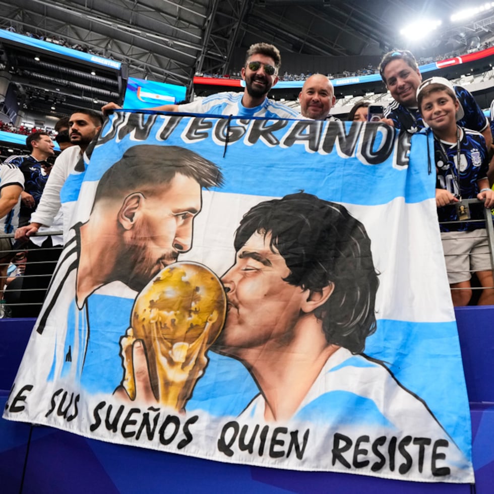 Fanáticos de Argentina sostienen una bandera con las imágenes de los astros argentinos Lionel Messi y Diego Maradona durante el Mundial de 2026.