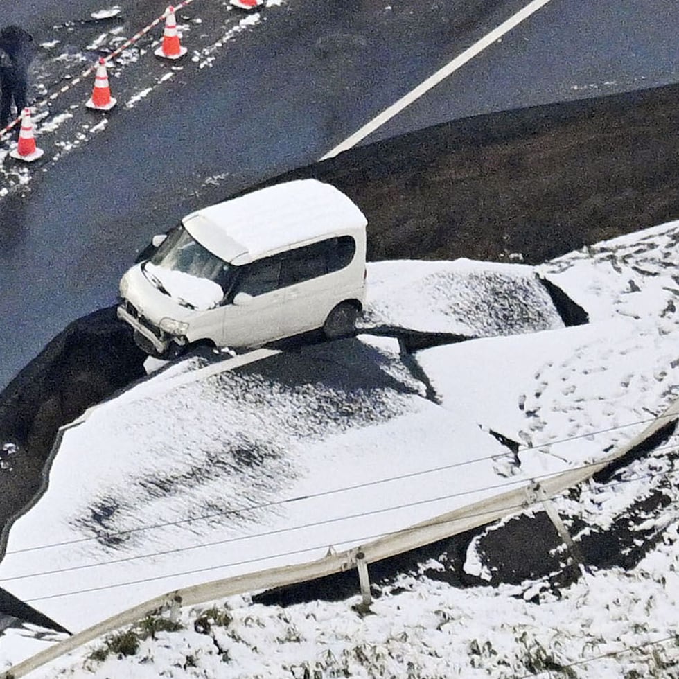 Esta foto aérea muestra un vehículo abandonado en una carretera dañada en la ciudad de Tohoku, prefectura de Aomori, al norte de Japón.