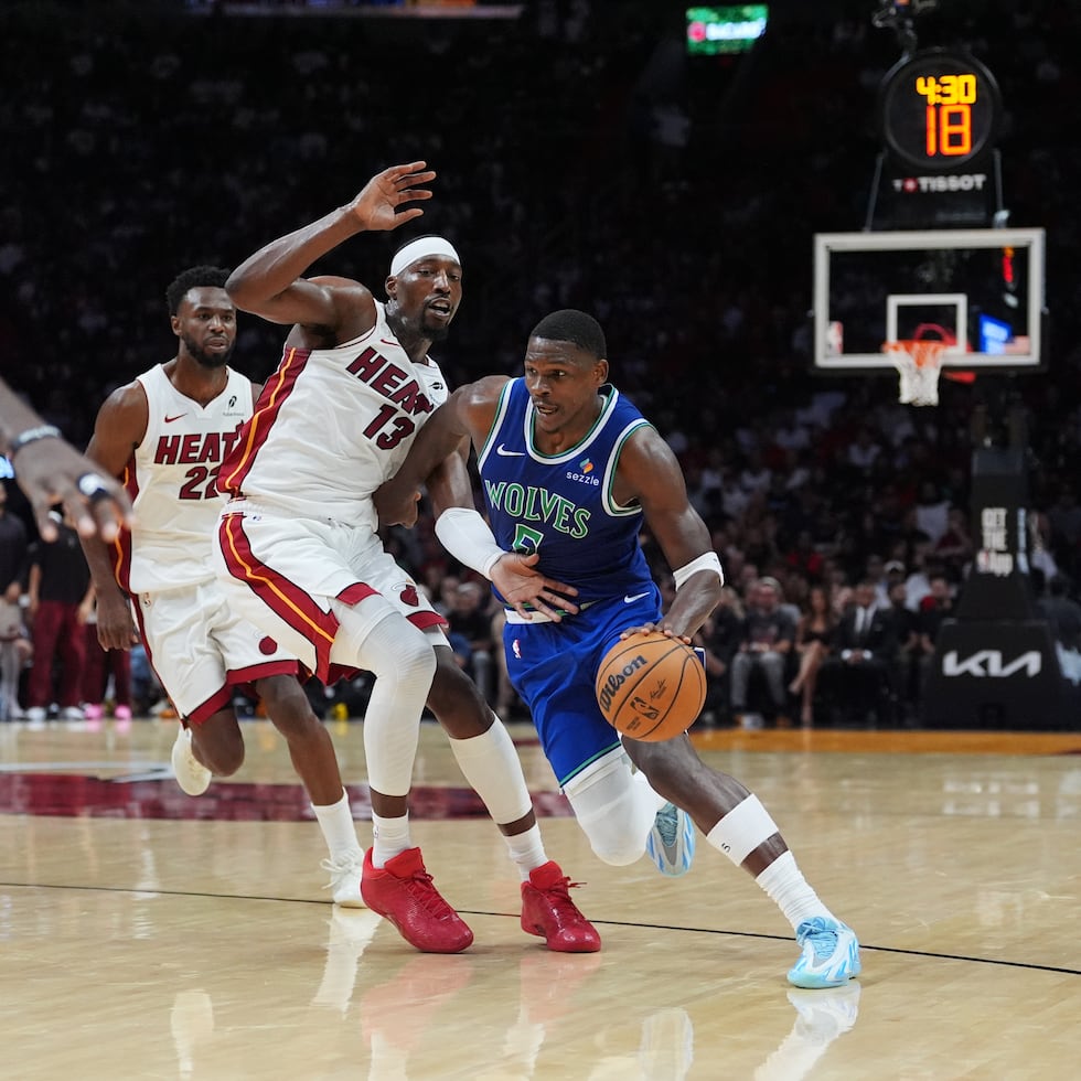 Anthony Edwards, base de los Timberwolves de Minnesota, elude a Bam Adebayo, del Heat de Miami, en el duelo del miércoles 21 de octubre de 2021 (AP Foto/Rebecca Blackwell)