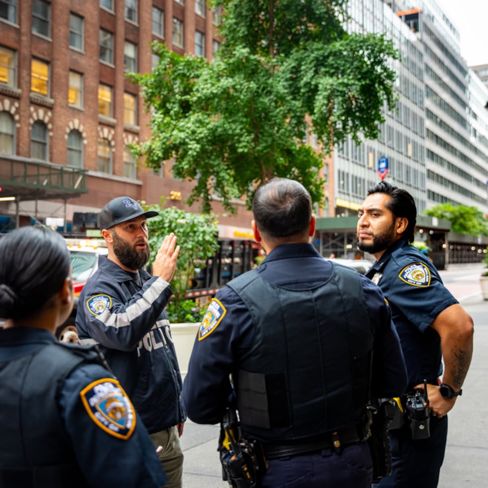 NYPD officers talk about buildings in the area that were evacuated, Tuesday, July 7, 2026, in New York. (AP Photo/Angelina Katsanis)