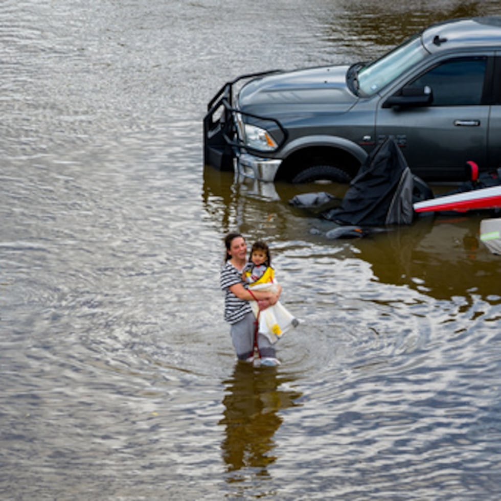 La gente vadea a través de un parque de caravanas inundado por las "Mareas del Rey", que se producen cuando el sol, la luna y la Tierra se alinean, causando una atracción gravitacional más fuerte el sábado 3 de enero de 2026, cerca de Corte Madera en el condado de Marin, California.