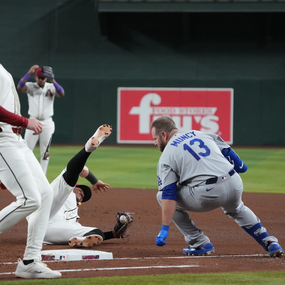 Max Muncy, de los Dodgers de Los Ángeles, y el primera base venezolano Ildemaro Vargas, de los Diamondbacks de Arizona, chocan durante el juego del jueves.