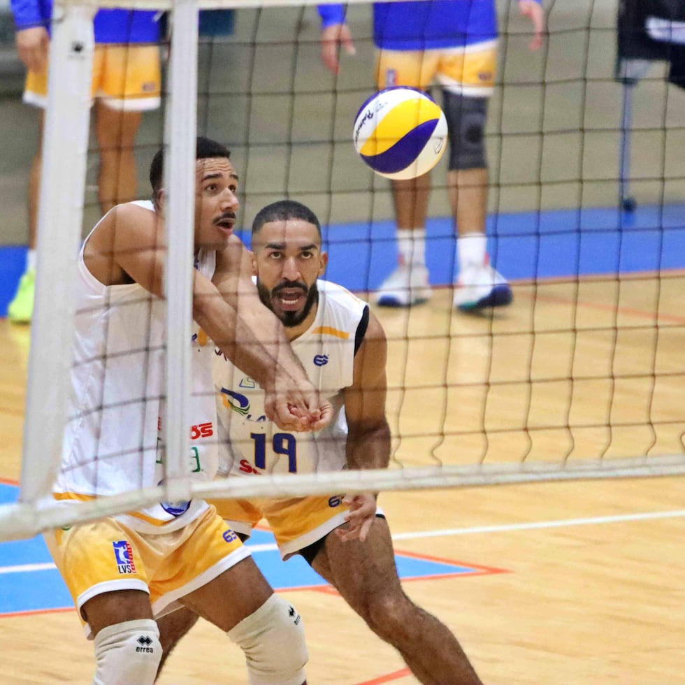 Joseph Oquendo, de los Plataneros de Corozal, bompea el balón mientras le observa su compañero Julio Mercedes.