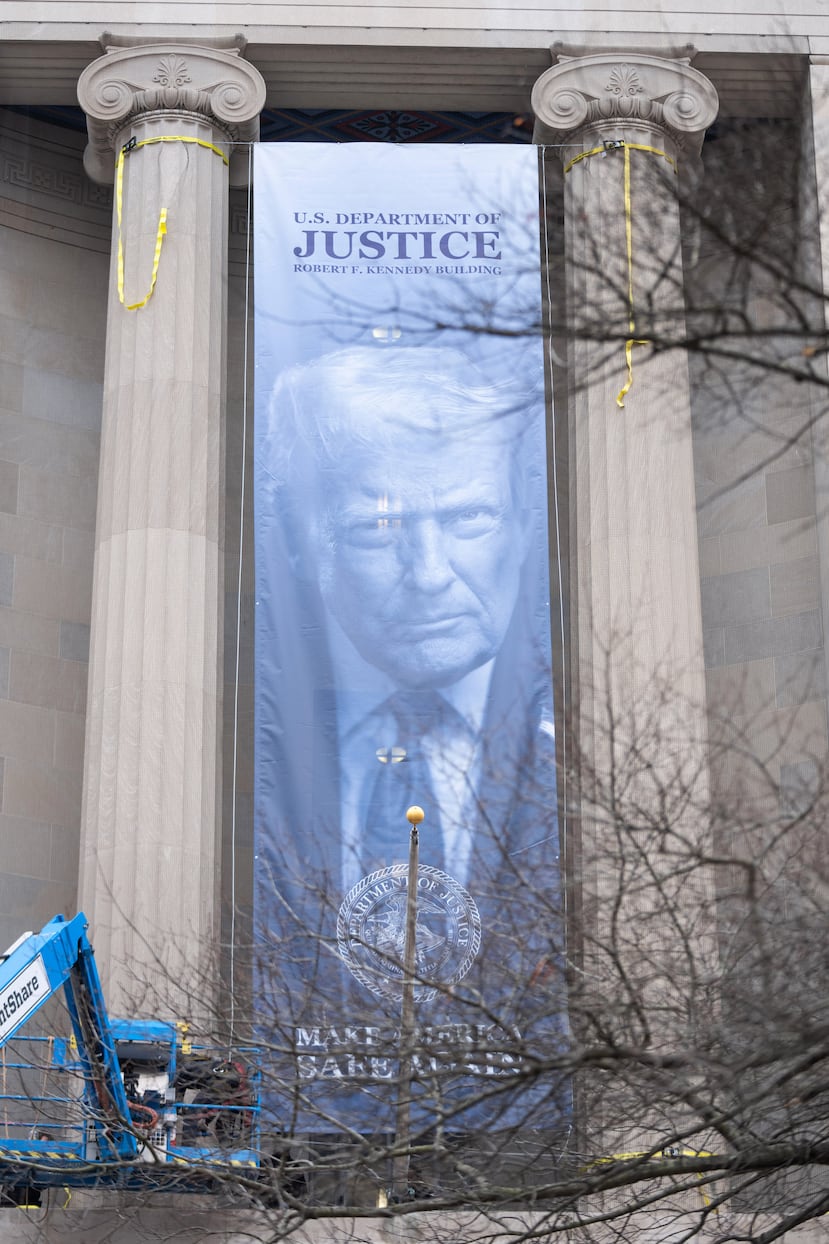 A banner showing President Donald Trump is hung from the Department of Justice, Thursday, Feb. 19, 2026, in Washington. (AP Photo/Allison Robbert)
