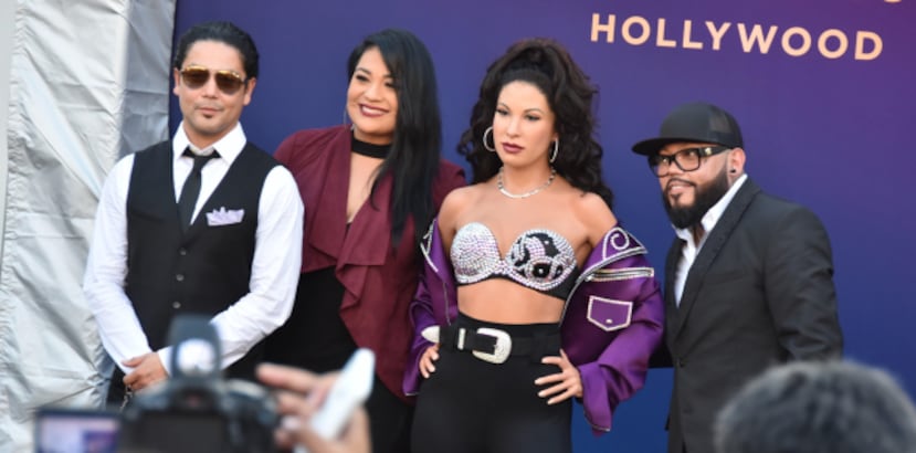 Los hermanos de Selena, A.B. y Suzette Quintanilla; y su viudo, Chris Pérez; posan con la figura. (Prensa Asociada)