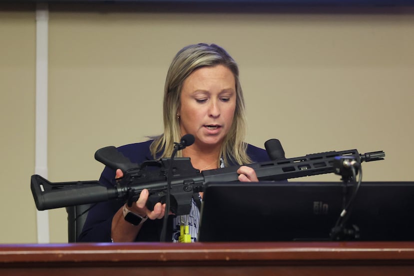 Ashley Gilland, investigadora de la fiscalía del condado de Barrow, examina el rifle de asalto utilizado en el tiroteo de la escuela secundaria Apalachee por el sospechoso Colt Gray durante la audiencia de sentencia de Gray en el Tribunal Superior del condado de Barrow, el lunes 27 de julio de 2026, en Winder, Georgia. (Jason Getz/Atlanta Journal-Constitution vía AP)