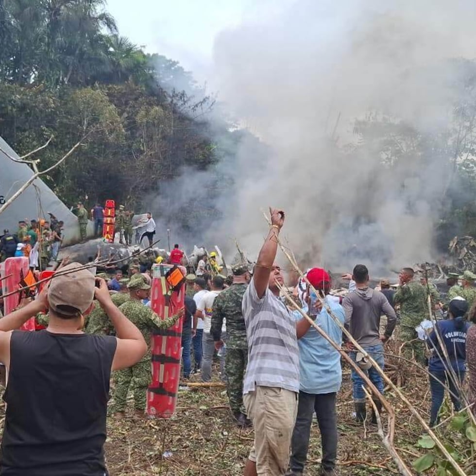 Muchas personas rodean un avión militar de carga que se estrelló el lunes 23 de marzo de 2026 tras despegar de Puerto Leguízamo en Colombia.