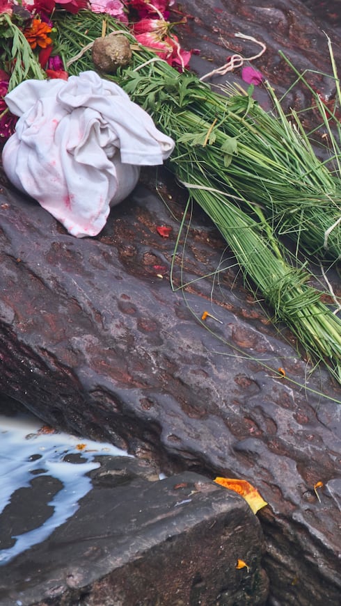 Una familiar rinde homenaje a la imagen de una persona desaparecida tras las inundaciones repentinas durante un funeral simbólico a orillas del río Bagmati, cerca del templo Pashupatinath, en Katmandú, Nepal.