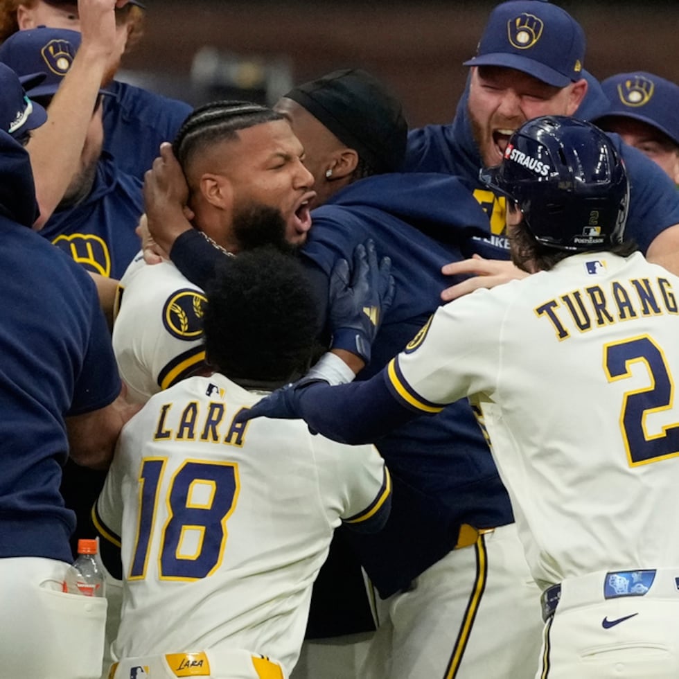 Jackson Chourio, al centro, es rodeado por sus compañeros de los Brewers de Milwaukee luego de conectar el sencillo que dejó sobre el terreno a los Padres de San Diego.
