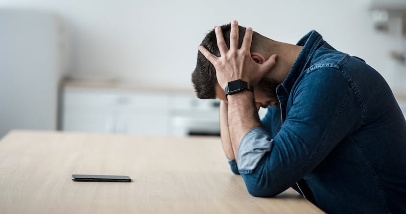 Un hombre se agarra la cabeza durante una crisis emocional.