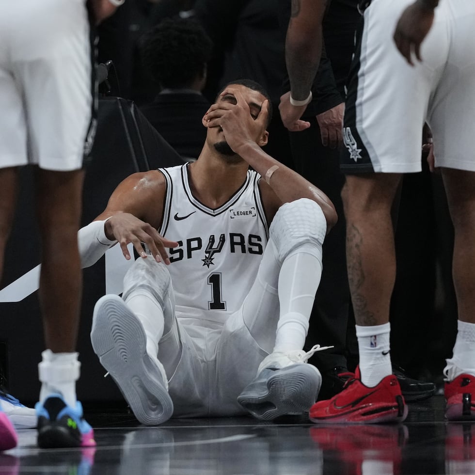 El delantero de los San Antonio Spurs, Victor Wembanyama (1), se sienta en la cancha tras una dura caída durante la primera mitad del segundo juego de una serie de primera ronda de los playoffs de la NBA contra los Trail Blazers de Portland.