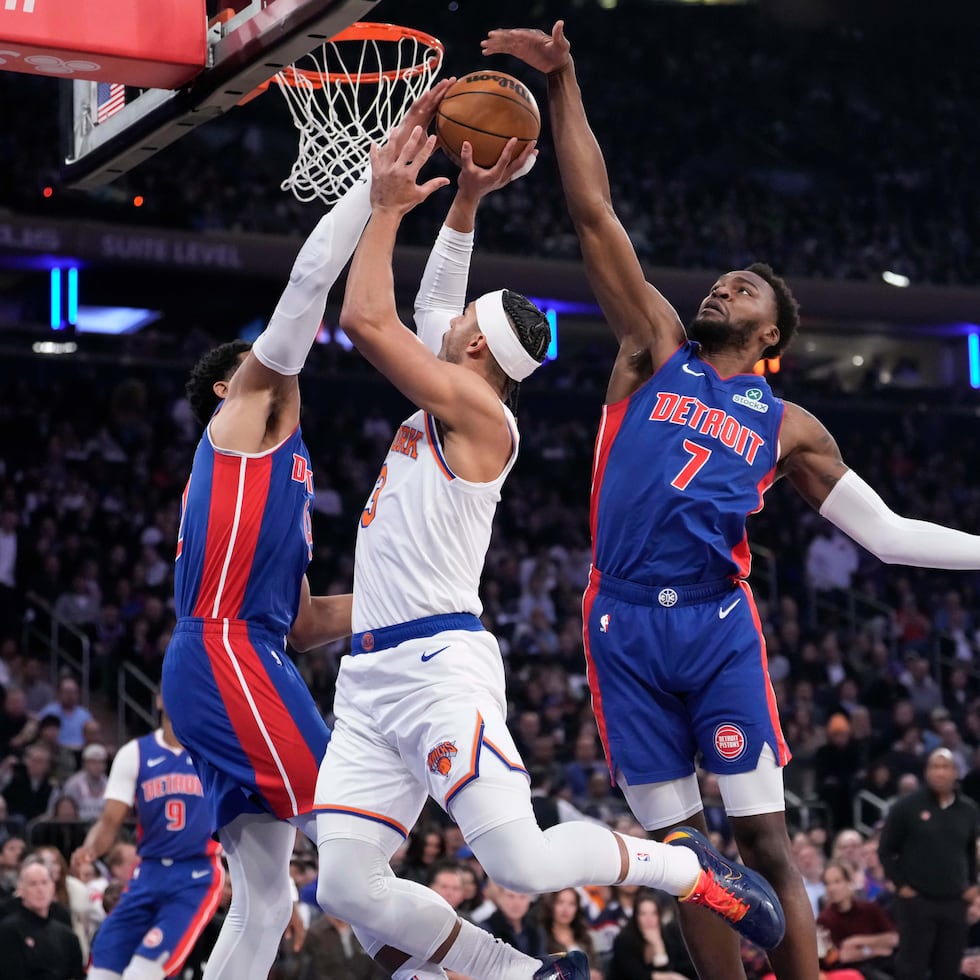 Paul Reed, de los Pistons de Detroit, intenta anotar con la defensa de los Knicks encima.