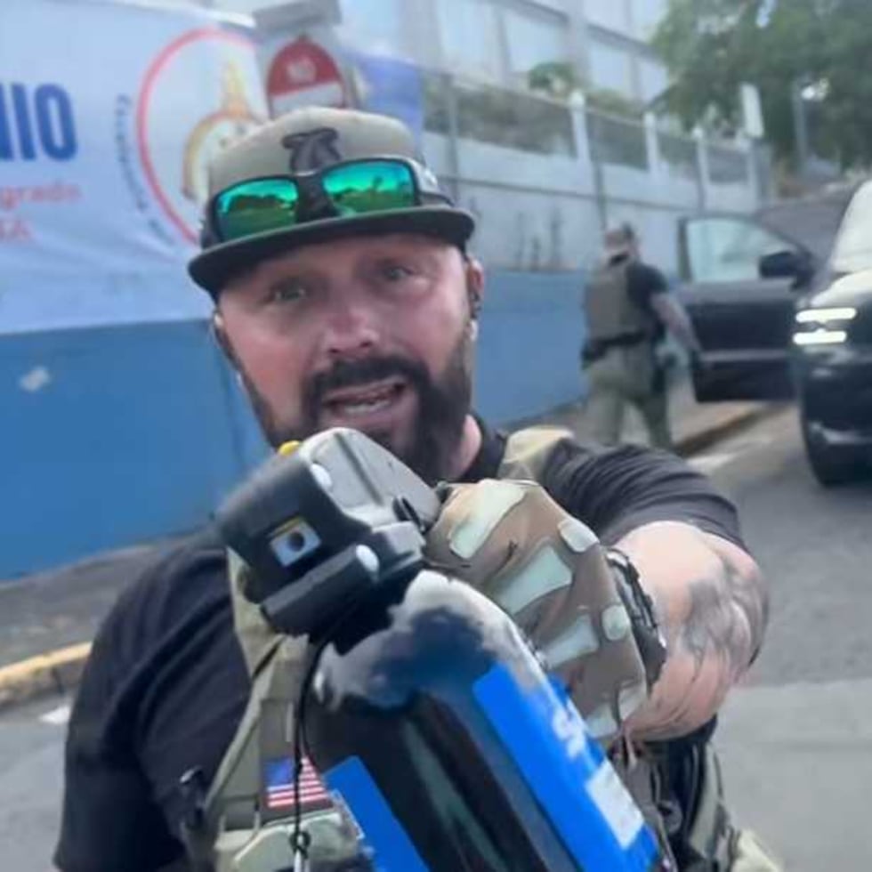 An ICE agent points a pepper spray canister towards a person documenting an immigration raid in the neighborhood of Río Piedras.