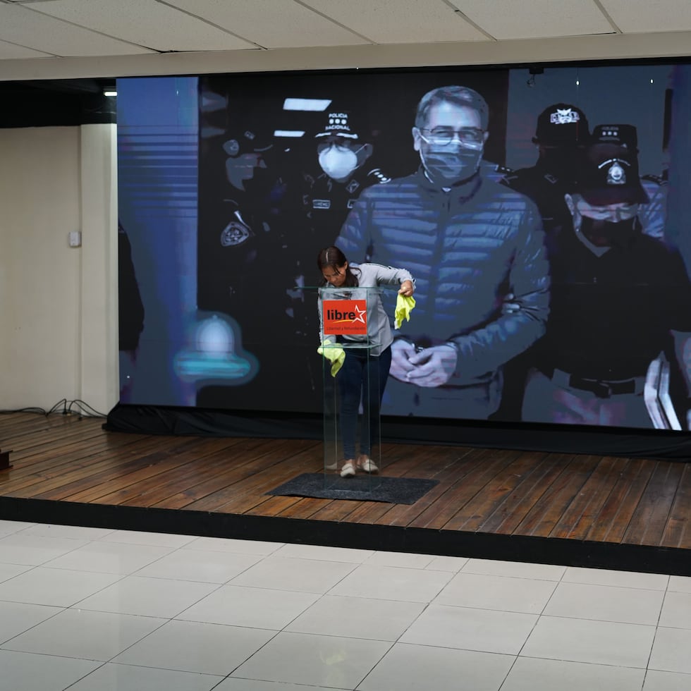 Una pantalla muestra la imagen del expresidente hondureño Juan Orlando Hernández, un día después de que el mandatario estadounidense Donald Trump dijera que planea indultarlo de una sentencia de narcotráfico emitida en 2024, antes del inicio de una conferencia de prensa de la candidata del partido en el poder, Rixi Moncada, en Tegucigalpa, Honduras, el sábado 29 de noviembre de 2025.