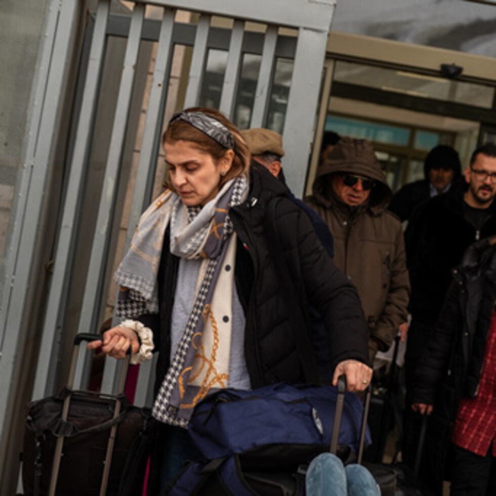 Personas, en su mayoría iraníes que cruzaron desde Irán por el paso fronterizo de Kapikoy, tiran de equipaje en la provincia oriental turca de Van, el viernes 6 de marzo de 2026. (AP Photo/Murat Kocabas)