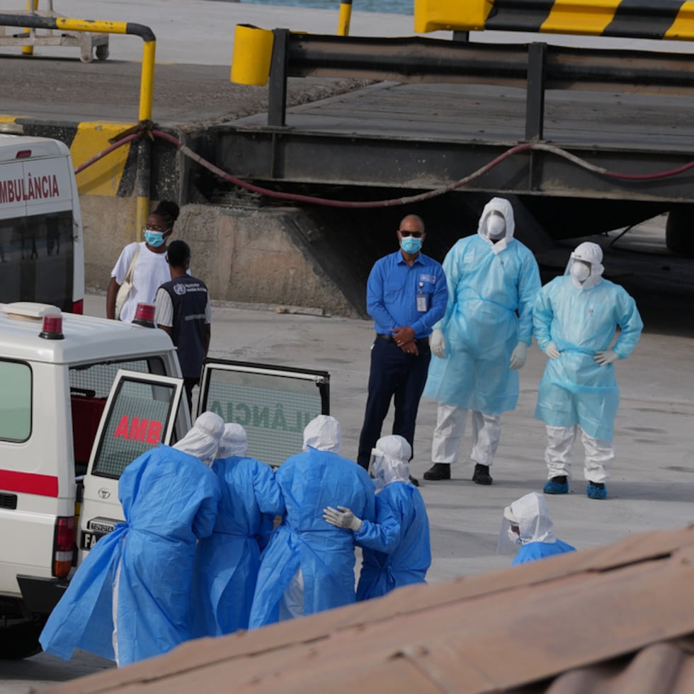 Trabajadores de salud con trajes de protección evacúan pacientes del crucero MV Hondius en una ambulancia en puerto Praia, en Cabo Verde.