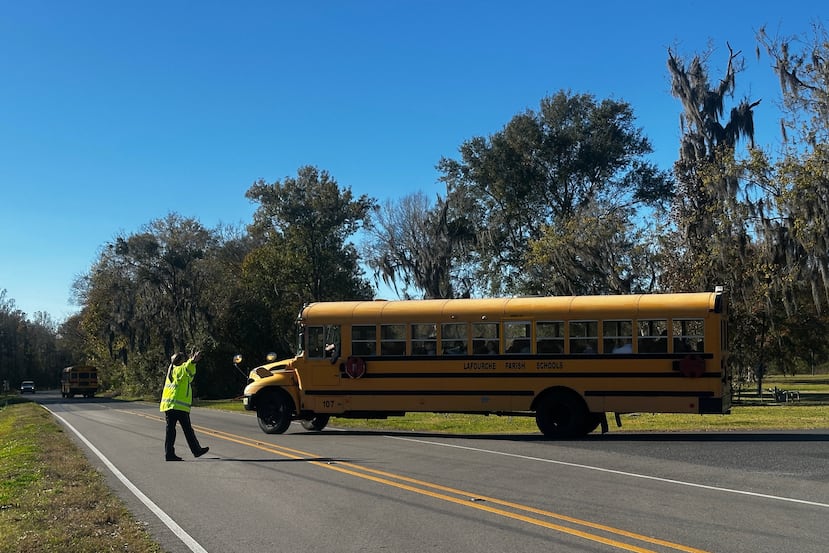 A school bus carries children at the end of a school day at Sixth Ward Middle School in Thibodaux, La., on Dec, 11, 2025. (AP Photo/Stephen Smith)