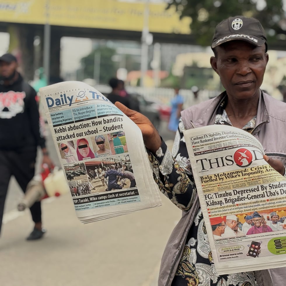 Un vendedor muestra diarios locales en una calle de Lagos con titulares sobre las alumnas secuestradas de la Escuela Secundaria Integral para Niñas del Gobierno, donde varios hombres armados atacaron el dormitorio escolar el lunes y secuestraron a las menores, en Nigeria, el miércoles 19 de noviembre de 2025.