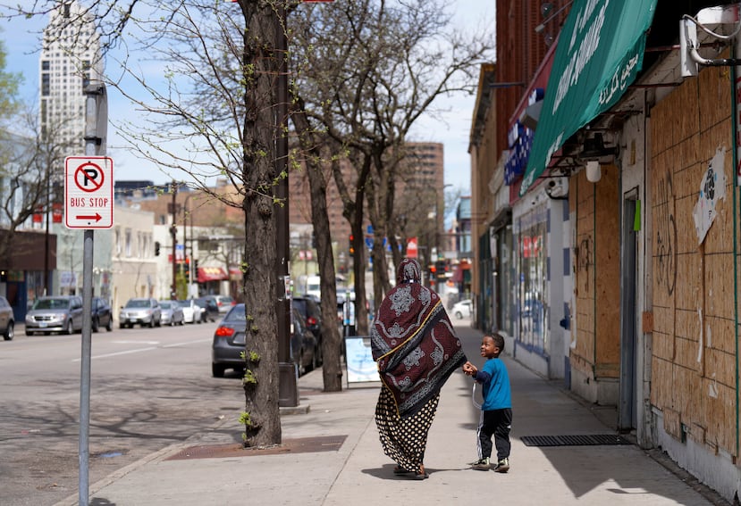 ARCHIVO - Una mujer y un niño caminan de la mano por una calle del barrio predominantemente somalí de Cedar-Riverside, en Minneapolis, el jueves 12 de mayo de 2022. (AP Foto/Jessie Wardarski/Archivo)