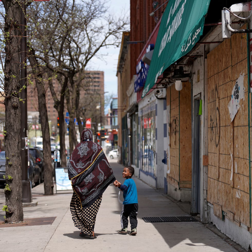 Ona mujer y un niño caminan de la mano por una calle del barrio predominantemente somalí de Cedar-Riverside, en Minneapolis. Donald Trump dijo sobre la comunidad somalí que "no contribuyen en nada. No los quiero en nuestro país".