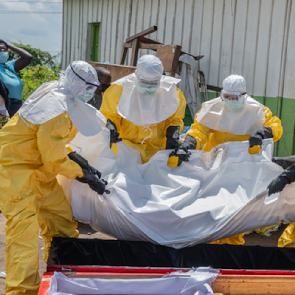 Trabajadores de la Cruz Roja colocan en un ataúd el cuerpo de una persona que murió de ébola, en un centro de salud en Rwampara, Congo, el 20 de mayo de 2026.