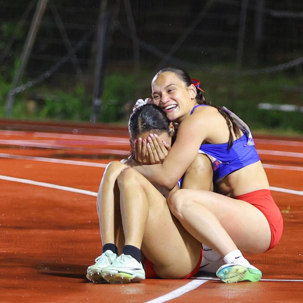 Frances Colón (izquierda) es abrazada por su compañera de equipo Gladymar Torres en la final de los 100 metros en Asunción.