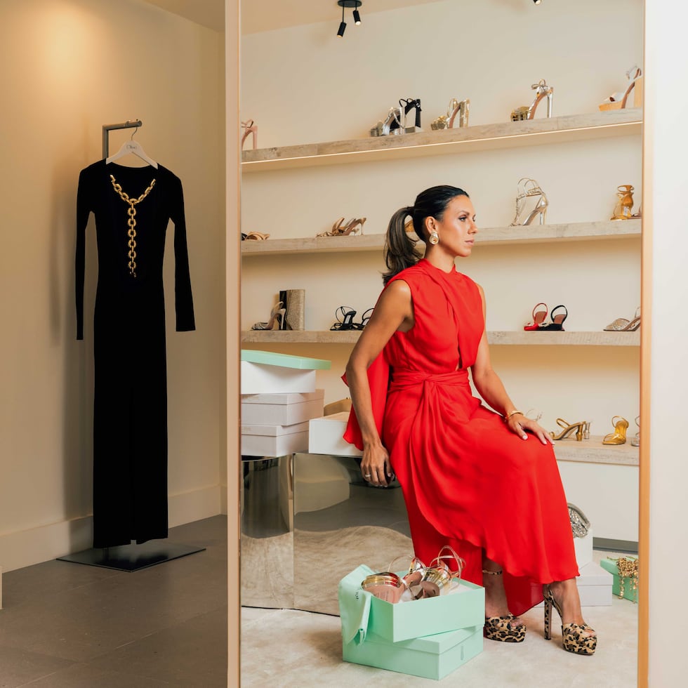 María Consuelo en vestido rojo de Johanna Ortiz, calzado Aquazzura y accesorios Julietta. El mobiliario estilo “ bench” de los años 80 en stainless steel pulido es Chris Hawker Style.