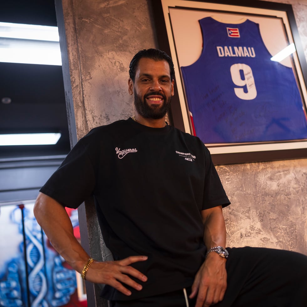 Christian Dalmau poses next to his Puerto Rico National Team jersey at The Perfect Workout gym in Bayamón.